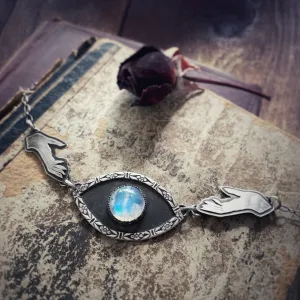 Hands reaching for moonstone eye necklace